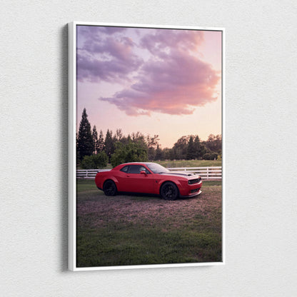 Red Dodge Challenger Hellcat parked in grassy field under purple and pink sunset sky canvas wall art.
