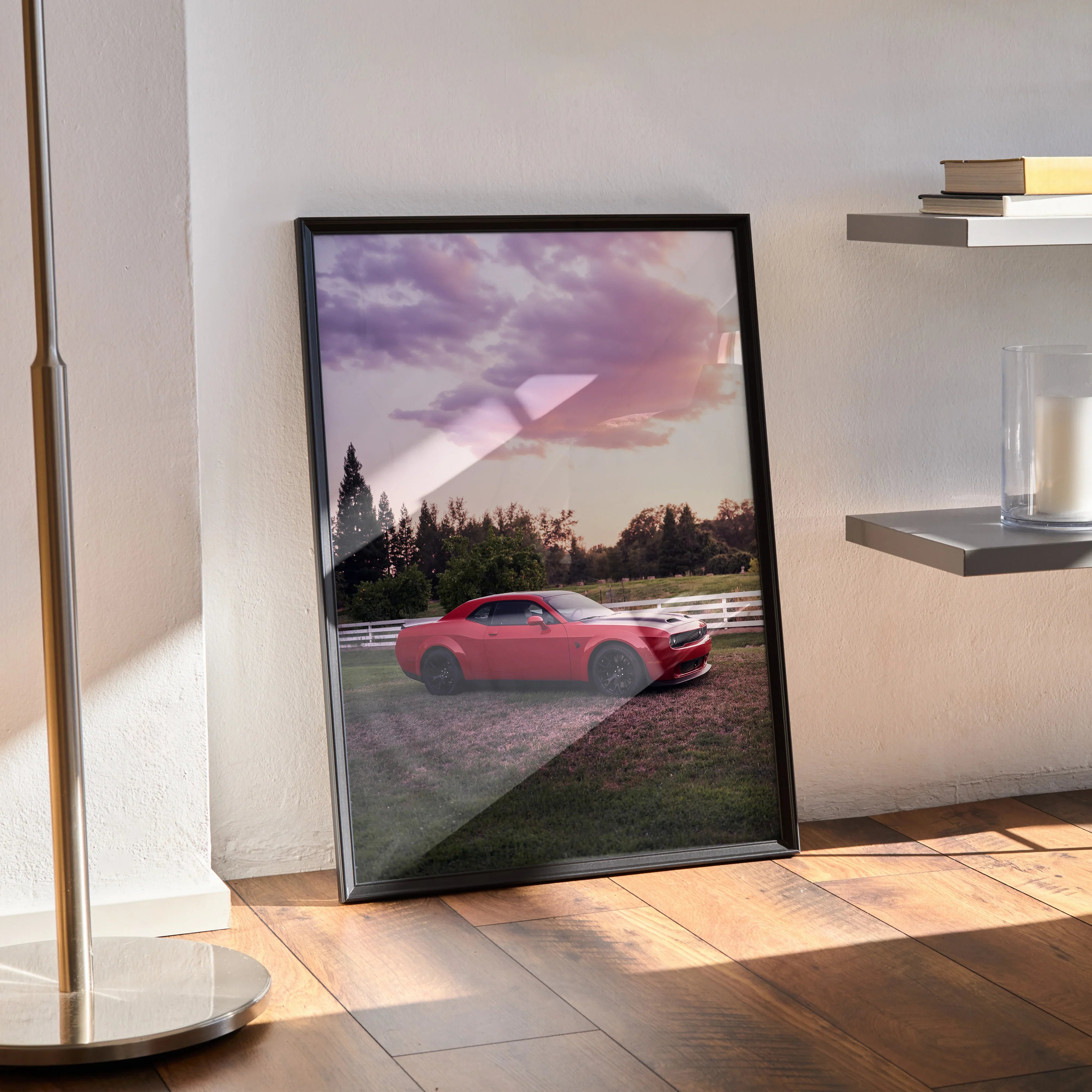 Dodge Challenger Hellcat in red at sunset poster framed as wall art leaning against wall on wooden floor.