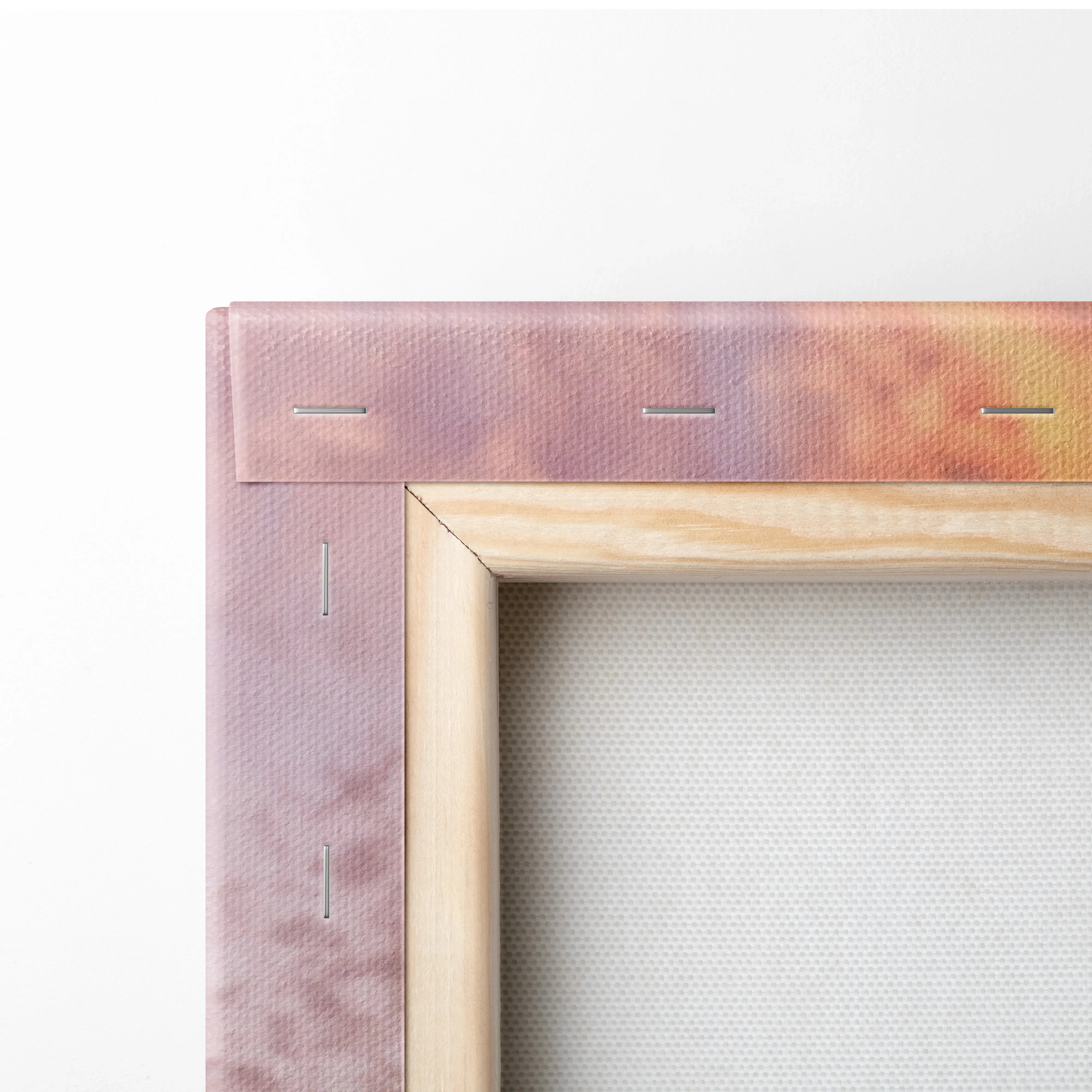 Close-up of wooden frame corner and pink textured canvas for wall art print.