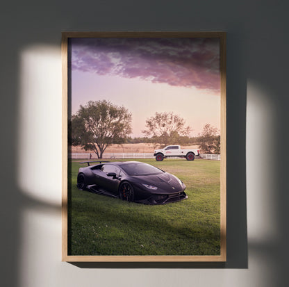 Lamborghini Huracan poster with black sports car and white SUV at sunset, framed wall art.