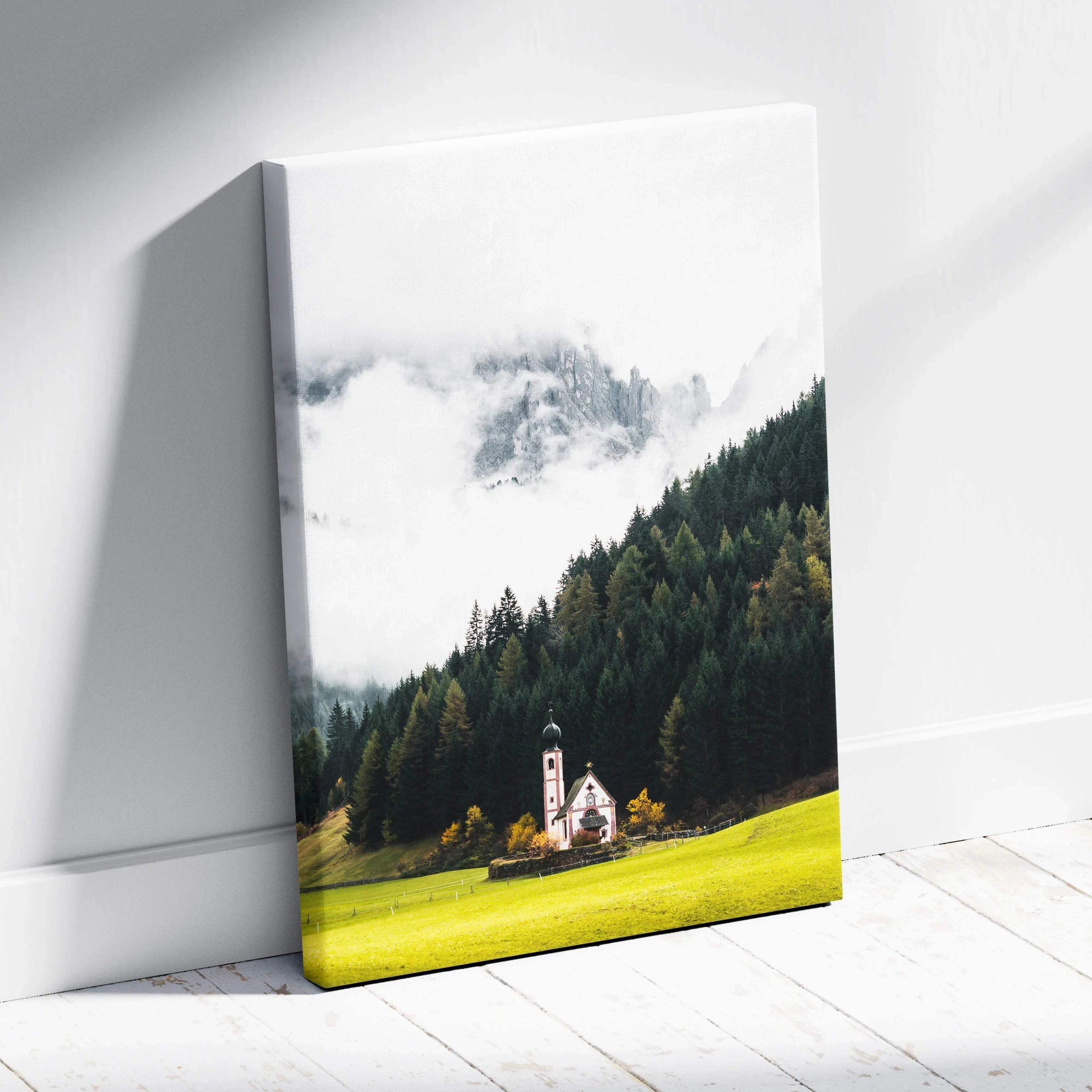 Canvas wall art featuring a small white church with a steeple set against a dense forest and misty mountain backdrop.
