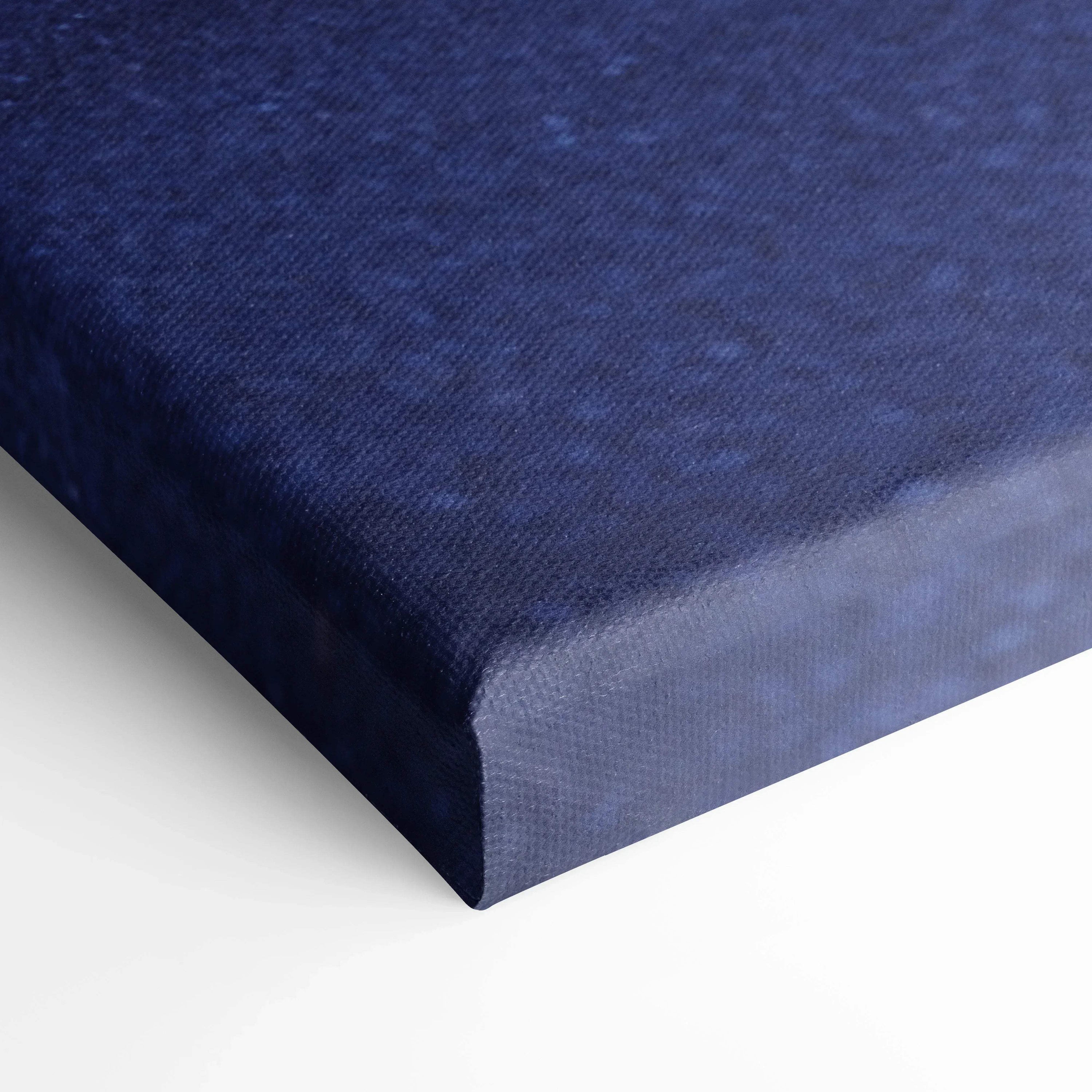 Close-up of deep blue textured canvas material for wall art wrapping a vertical canvas print corner.
