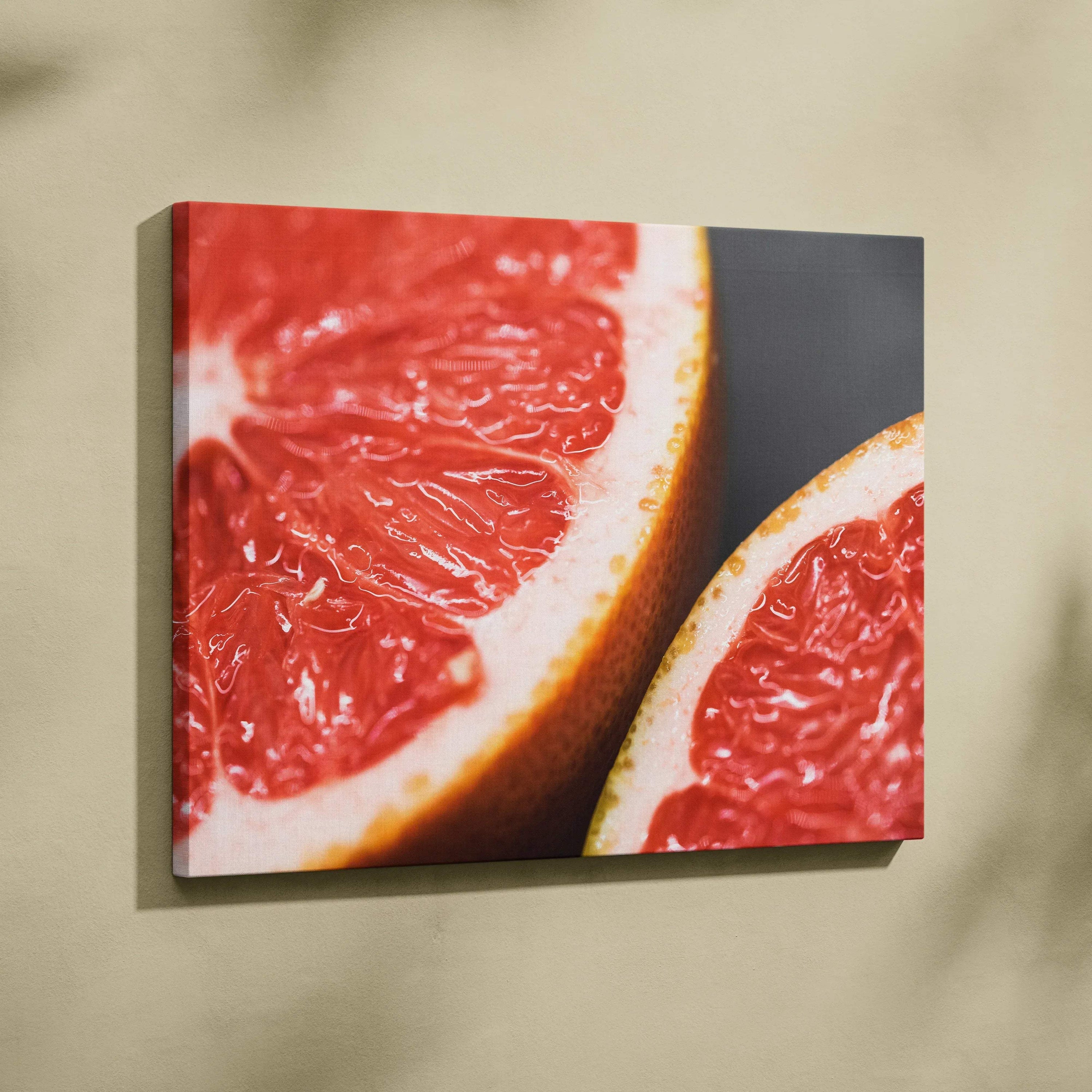Canvas wall art featuring a close-up of vibrant red grapefruit slices with a dark background for modern decor.