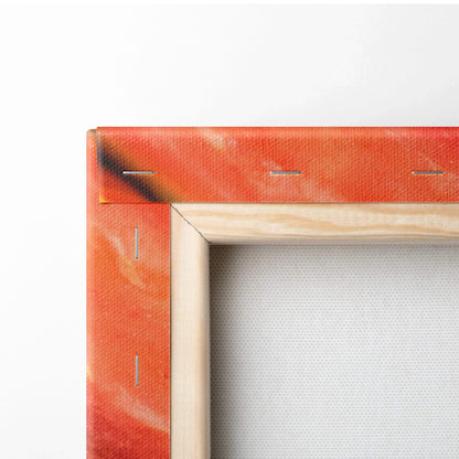 Close-up of wooden frame corner with orange-red tinted canvas stretched and stapled on back for wall art decor.