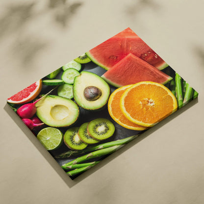 Colorful canvas wall art featuring fresh fruit slices including oranges, watermelon, kiwi, avocado, lime, and radishes on a.