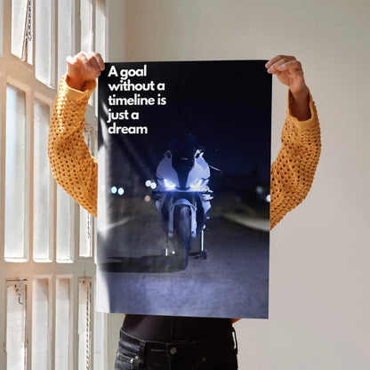 BMW S1000RR motorcycle poster with inspirational text "A goal without a timeline is just a dream" wall art in dark tones.