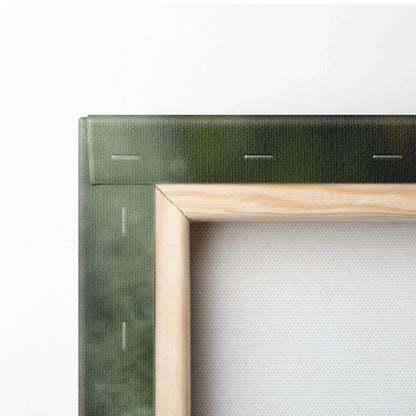 Close-up of wooden frame and green canvas edge with visible staples on wall art decor.