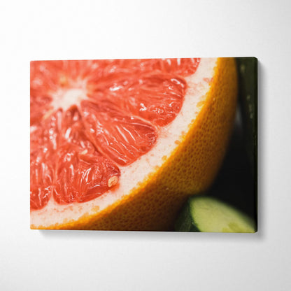 Bright grapefruit close-up canvas wall art with vibrant orange and pink tones for modern decor.