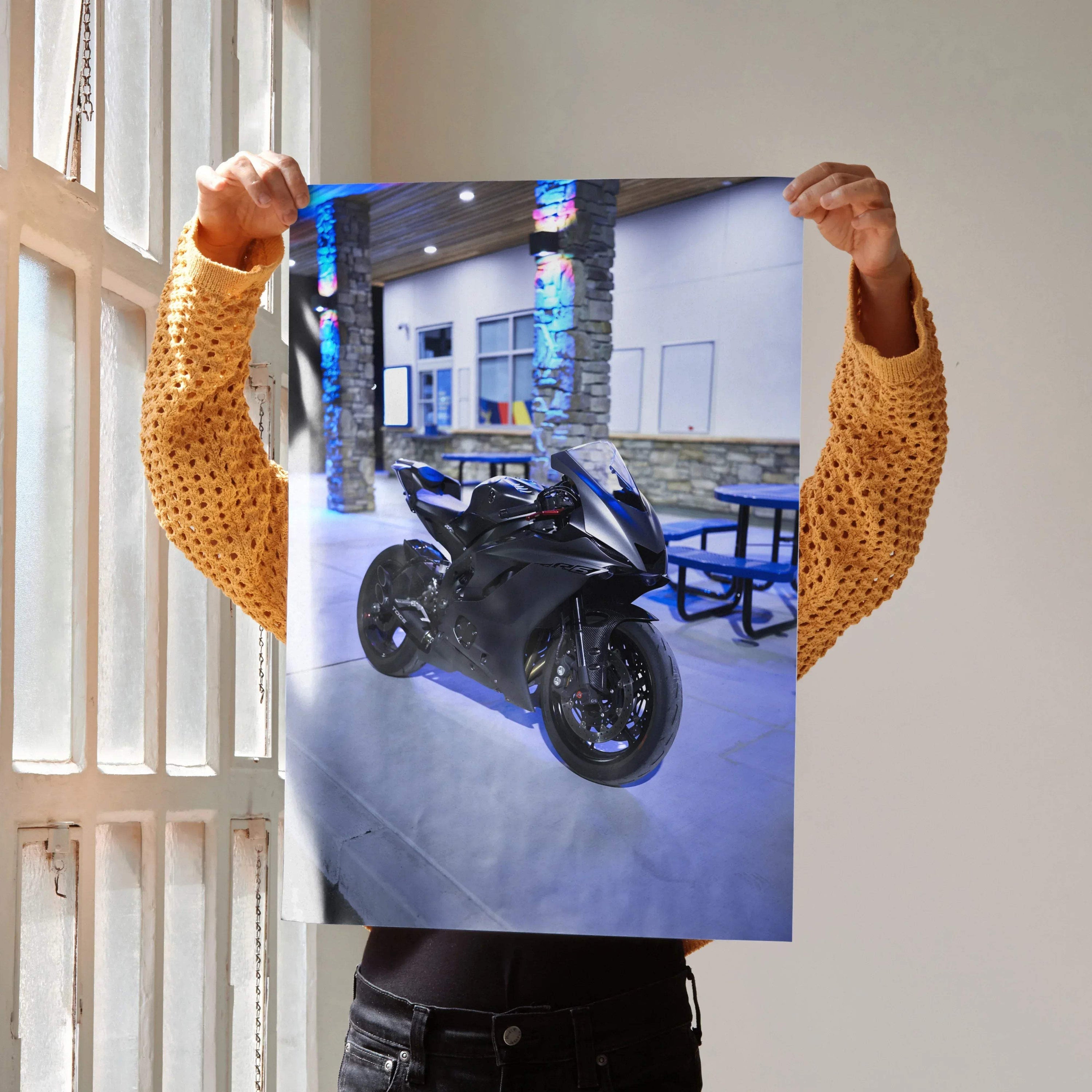 Yamaha R6 black motorcycle poster held up as wall art with urban nighttime backdrop.