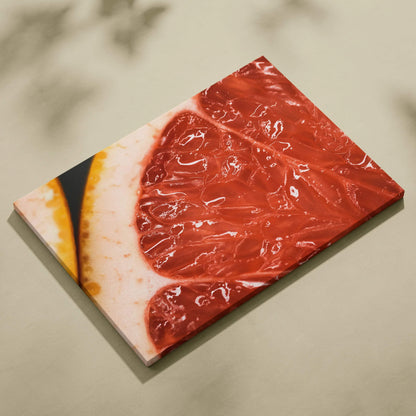 Canvas wall art featuring a detailed close-up of a vibrant red grapefruit slice with glossy texture and rich color contrast.