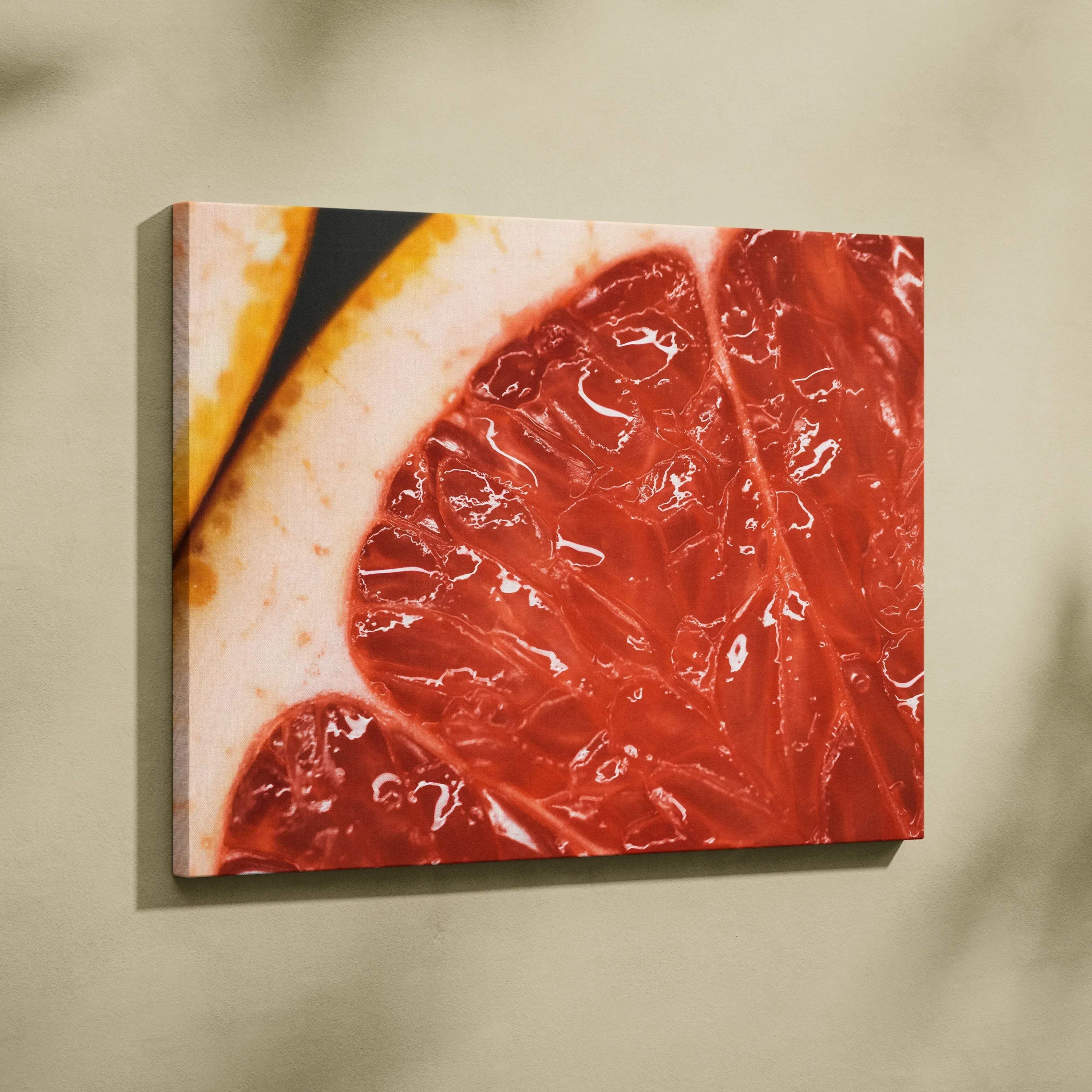 Close-up canvas wall art featuring detailed, vibrant red and pink grapefruit slices with white and yellow rind accents.