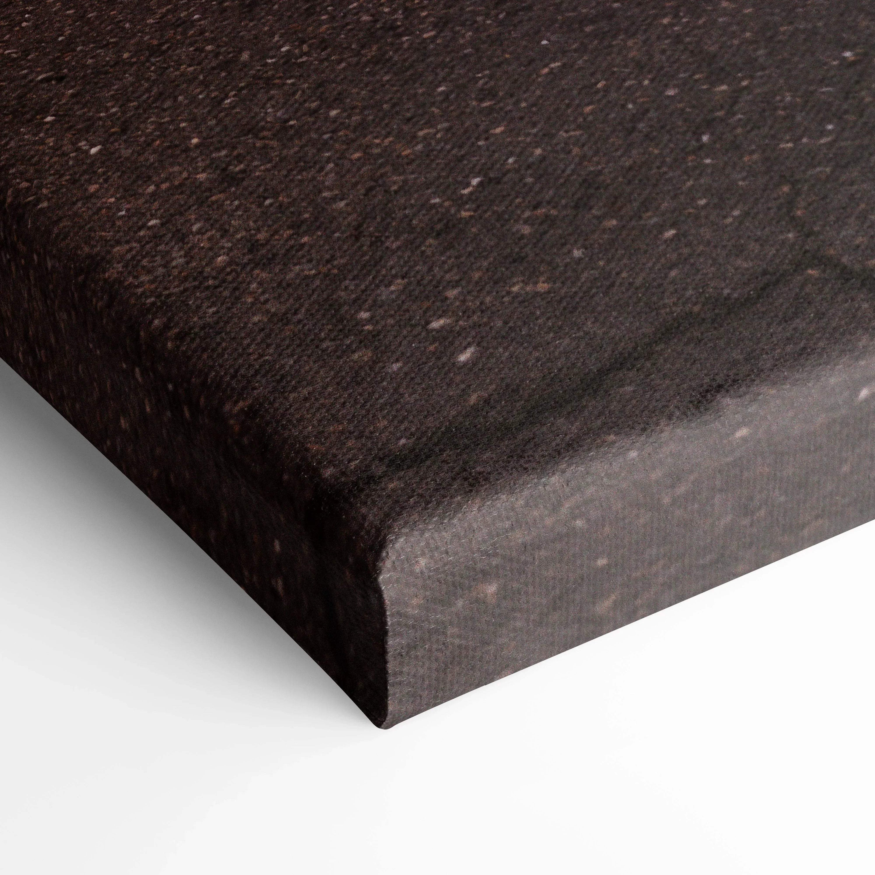 Close-up of textured black canvas corner with wrapped edge, showcasing museum-quality wall art material.