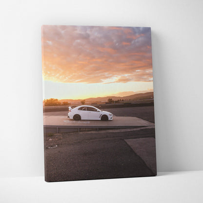 Vertical canvas wall art featuring a white Mitsubishi Evo 10 against a vibrant sunset sky.