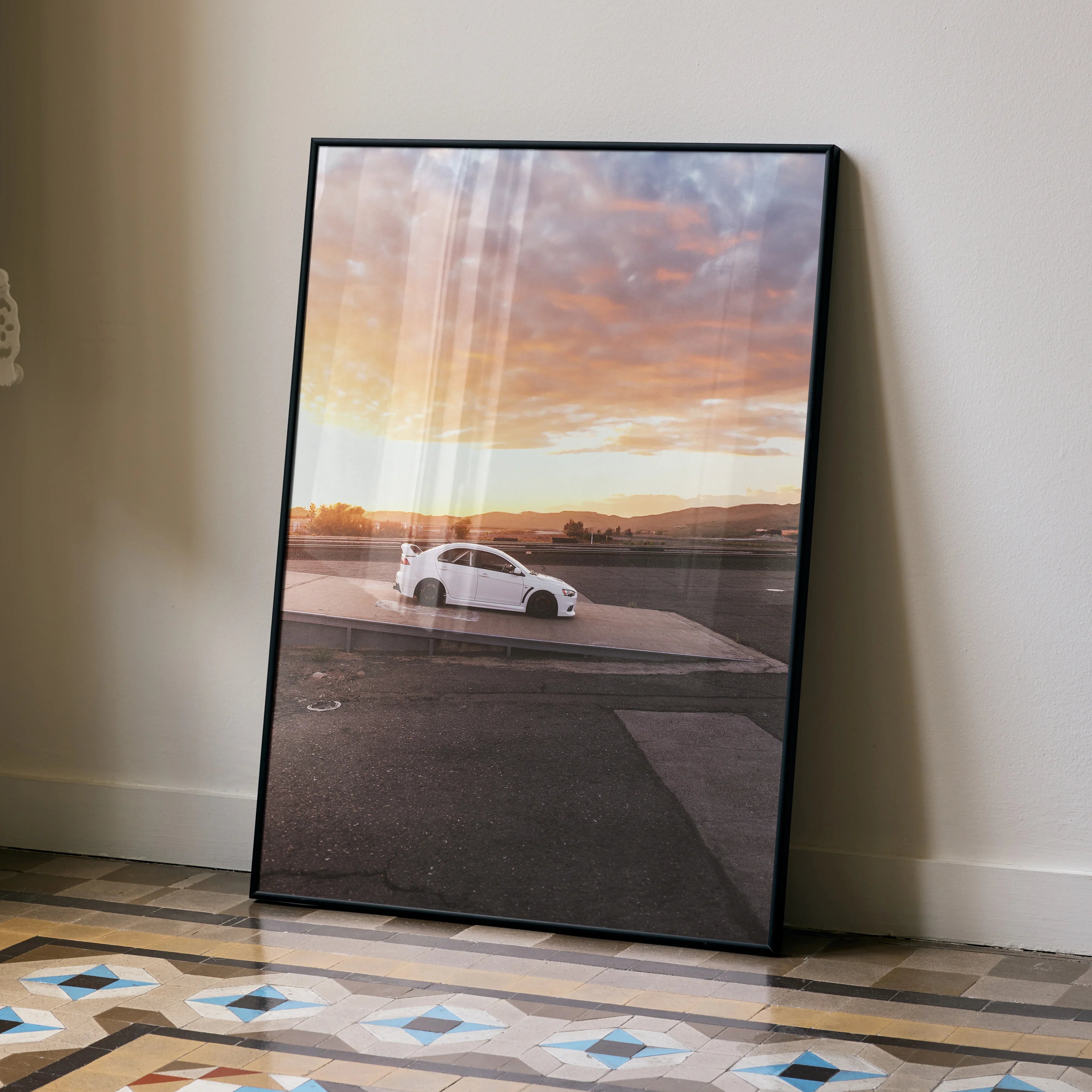 Mitsubishi Evo 10 poster with sunset background displayed as sleek wall art in black frame.