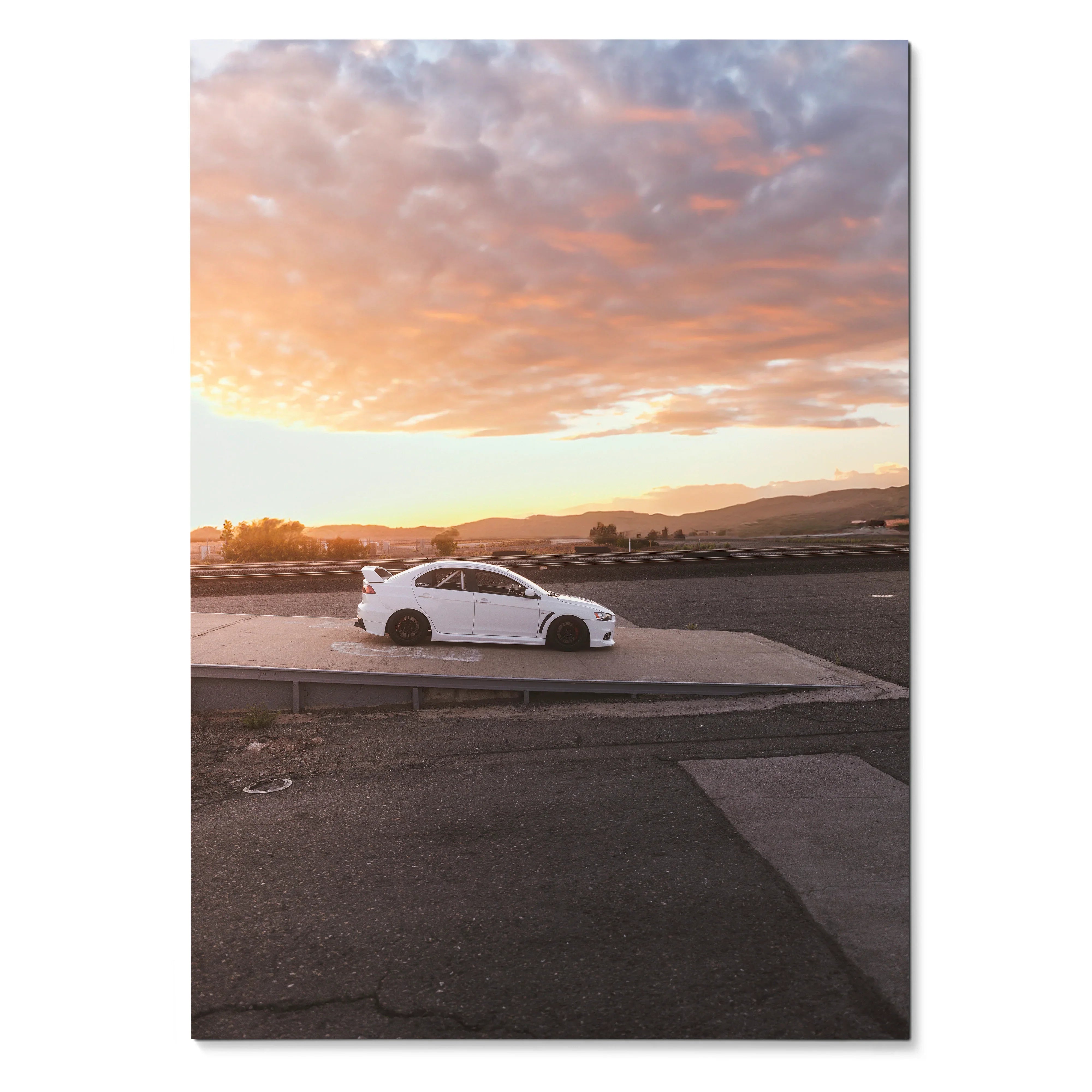 White Mitsubishi Evo 10 parked on asphalt at sunset, automotive poster wall art with dramatic sky.