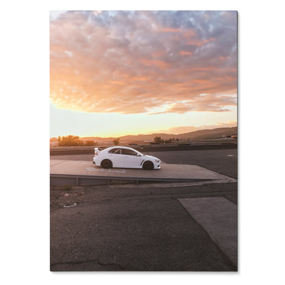 White Mitsubishi Evo 10 parked on asphalt at sunset, automotive poster wall art with dramatic sky.