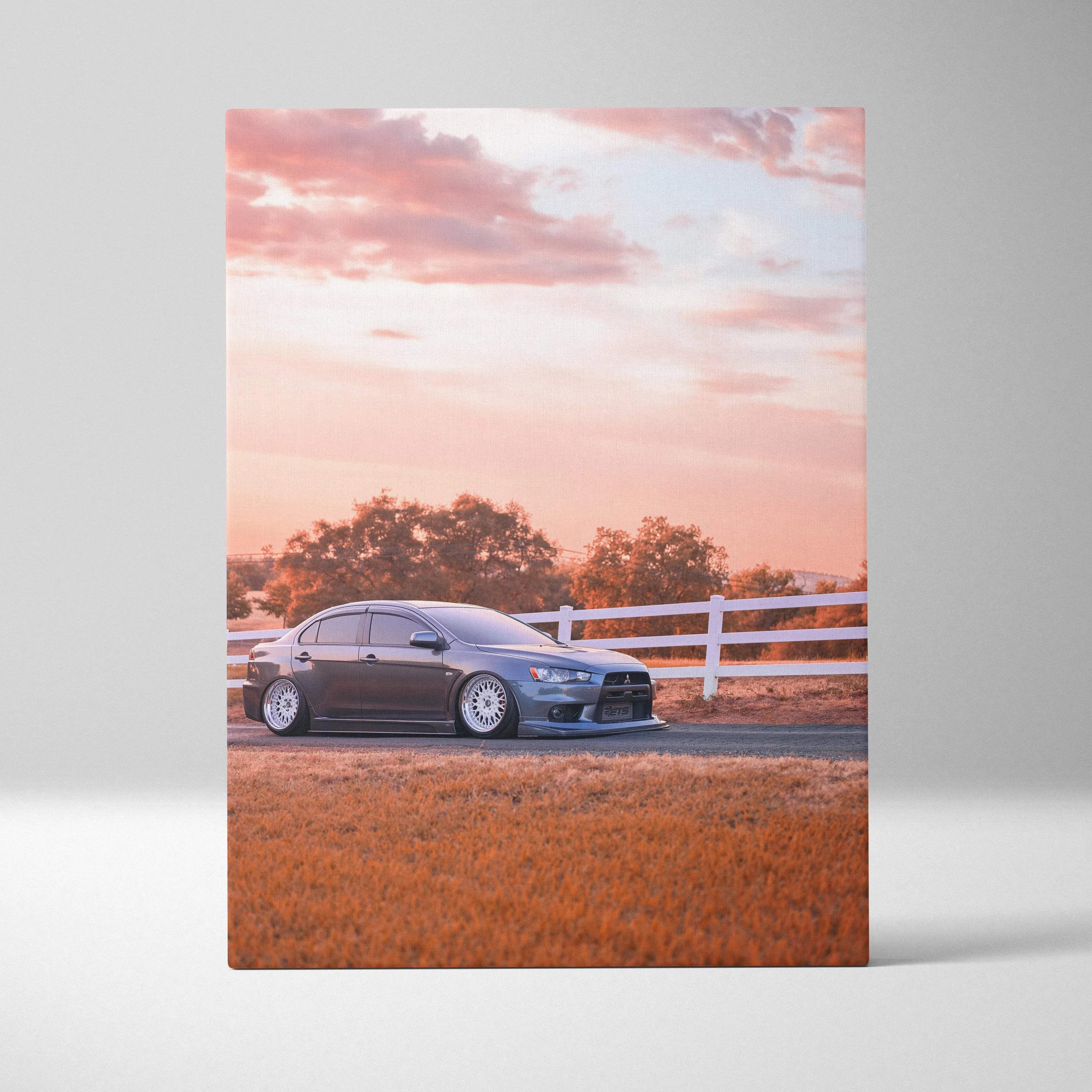 Mitsubishi Evo 10 parked by white fence at sunset on vertical canvas wall art.