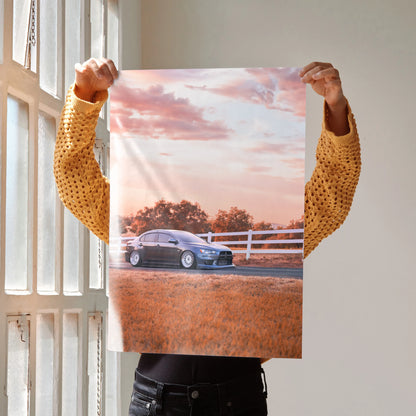 Mitsubishi Evo 10 poster featuring car at sunset with vibrant sky, ideal wall art for automotive fans.