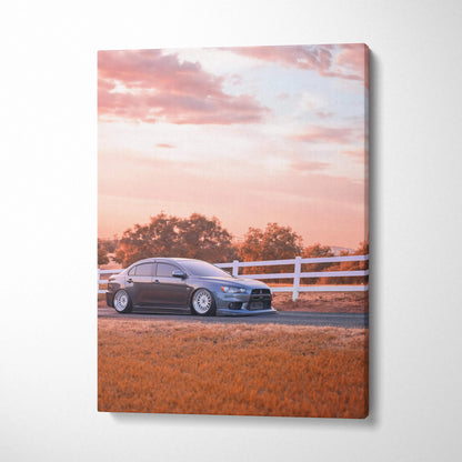 Mitsubishi Evo 10 canvas art showing sleek black car against sunset sky with fence and trees wall art.