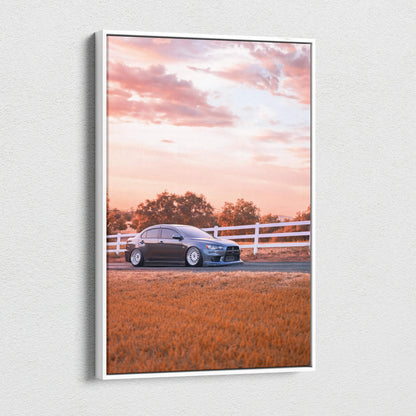 Vertical canvas wall art featuring a Mitsubishi Evo 10 car against a sunset sky with fence and grass.