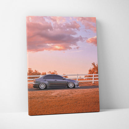 Mitsubishi Evo 10 parked in front of white fence at sunset on vertical canvas wall art.