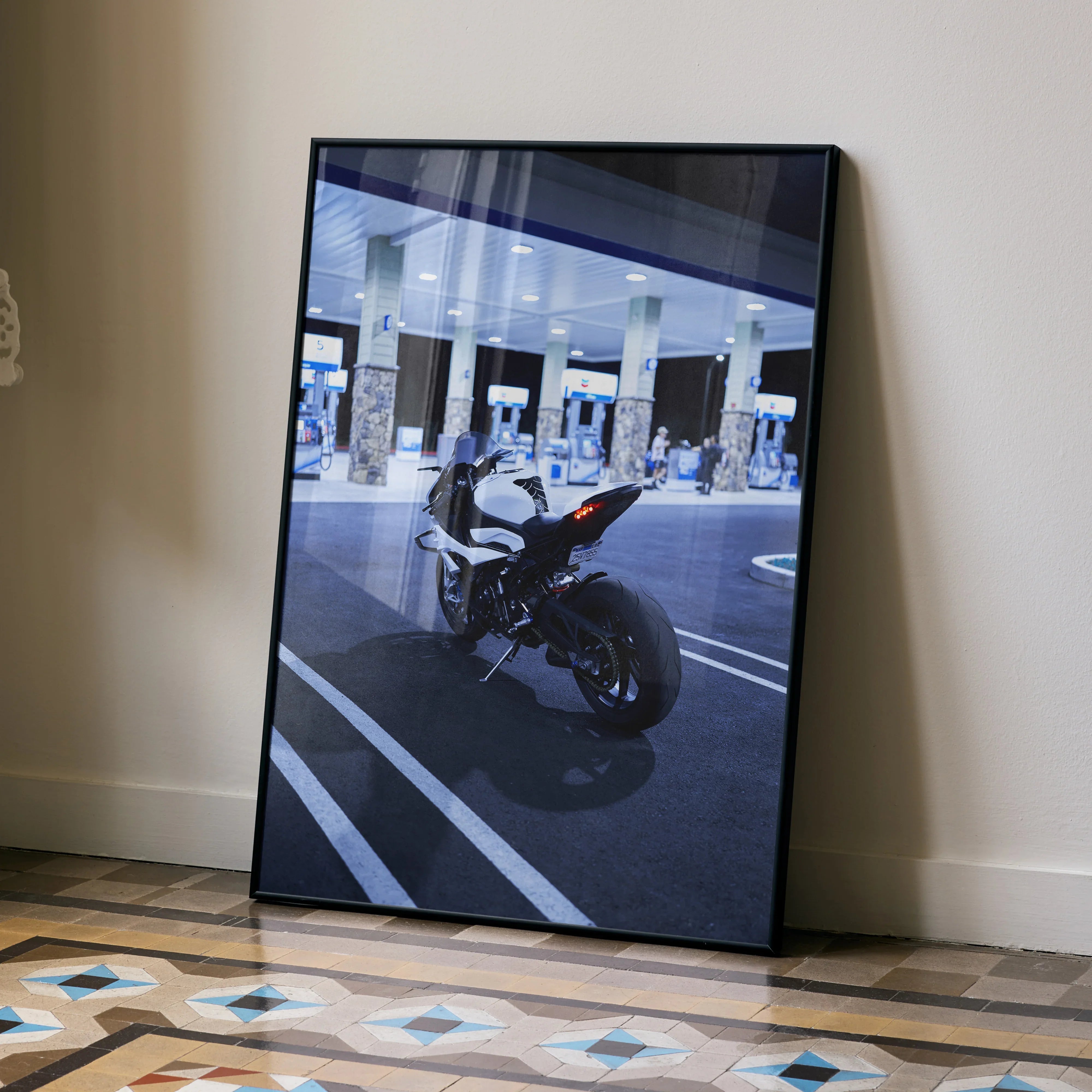BMW S1000RR motorcycle poster in black frame leaning on wall, urban night scene wall art.