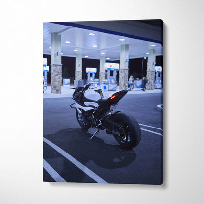 Vertical canvas wall art featuring a black BMW S1000RR motorcycle parked at a gas station at night.