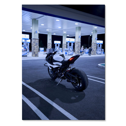 BMW S1000RR motorcycle parked at night under gas station lights poster wall art.