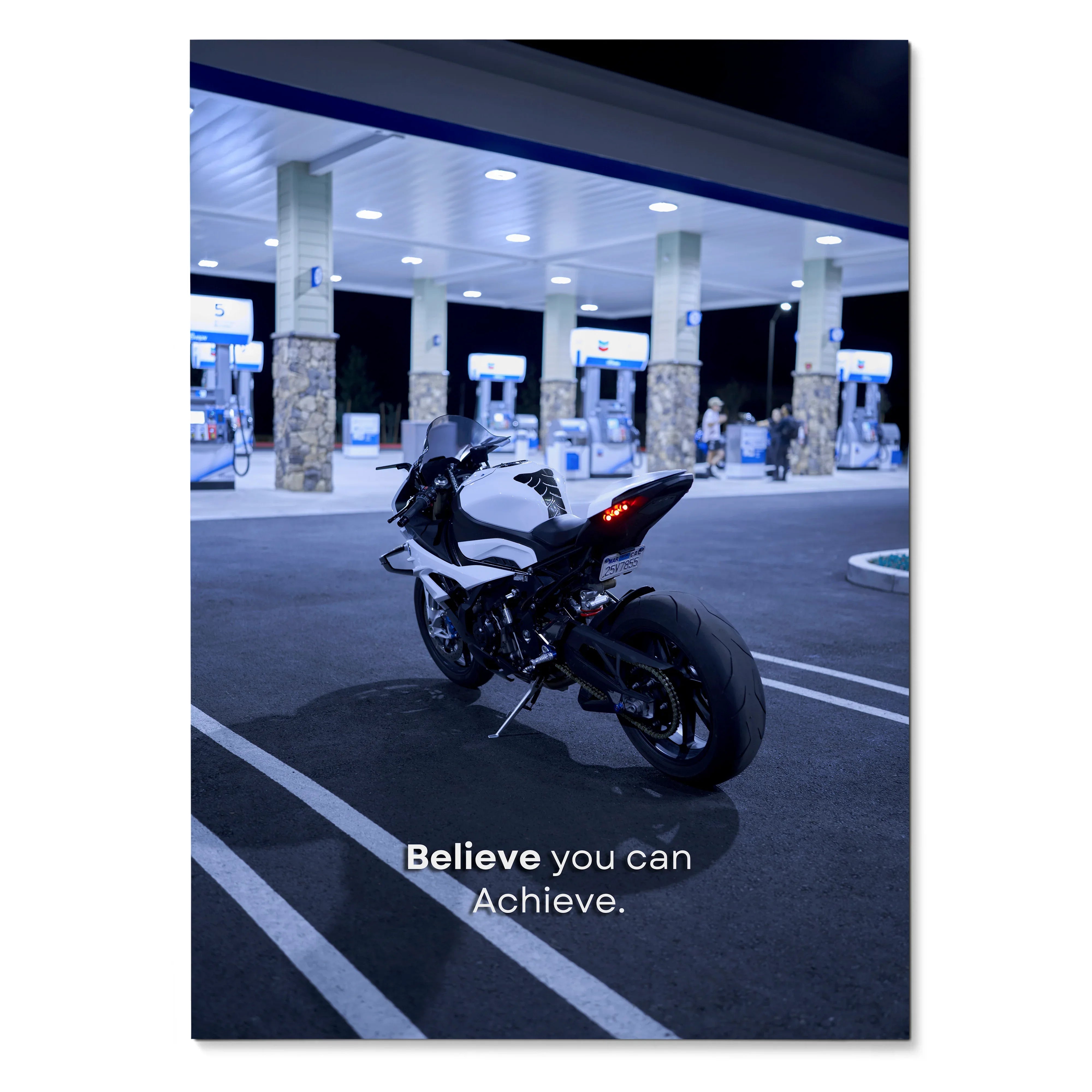 BMW S1000RR motorcycle parked at night under gas station lights with motivational text poster wall art.