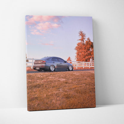 Vertical canvas wall art featuring a Mitsubishi Evo 10 parked on grass with autumn trees in the background.