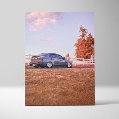 Vertical canvas art of a Mitsubishi Evo 10 parked on grass with autumn trees and blue sky wall art.