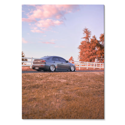 Mitsubishi Evo 10 car parked on grass with pink sky sunset poster wall art.