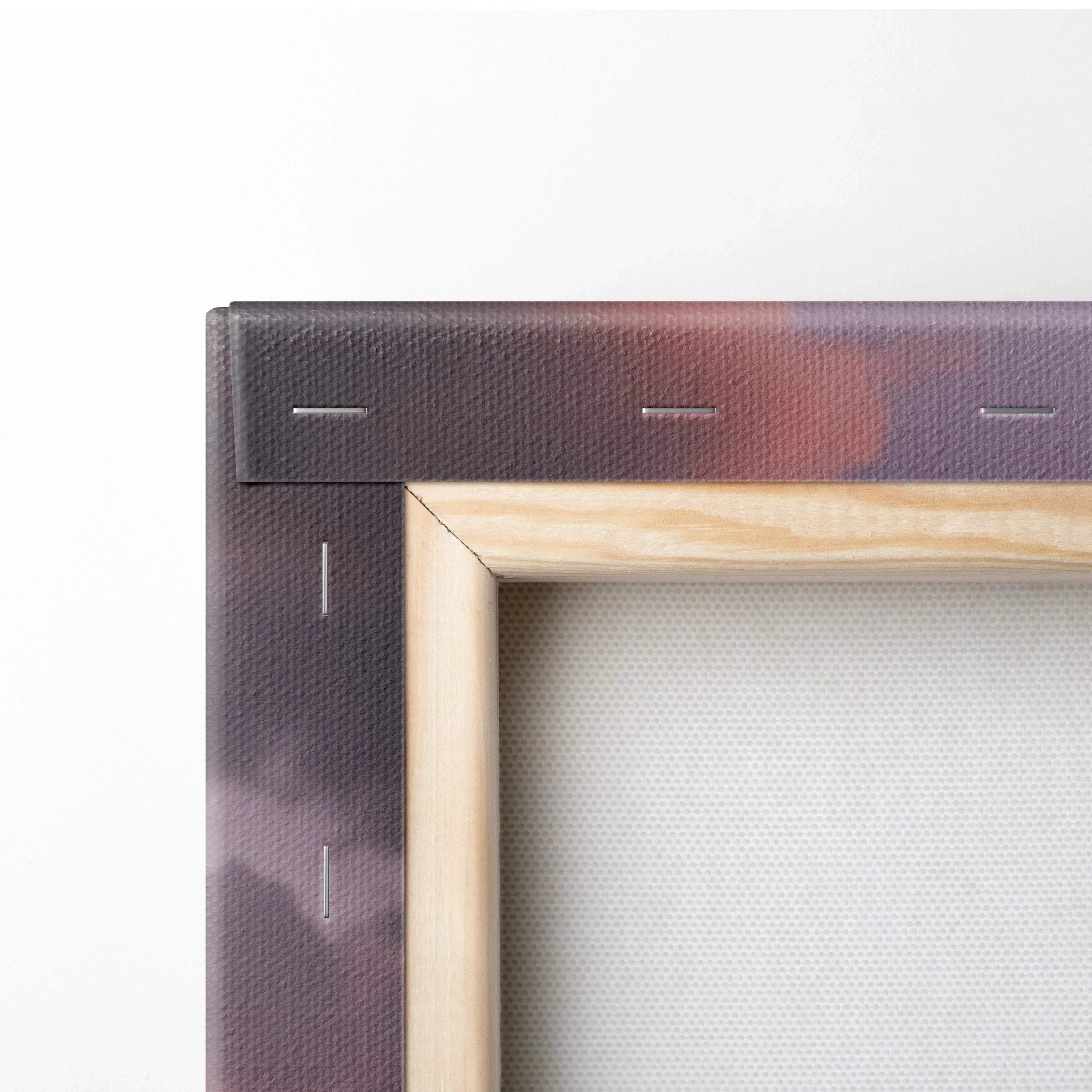 Close-up of stretched canvas corner with visible wooden frame and dark sunset colors on wall art print.