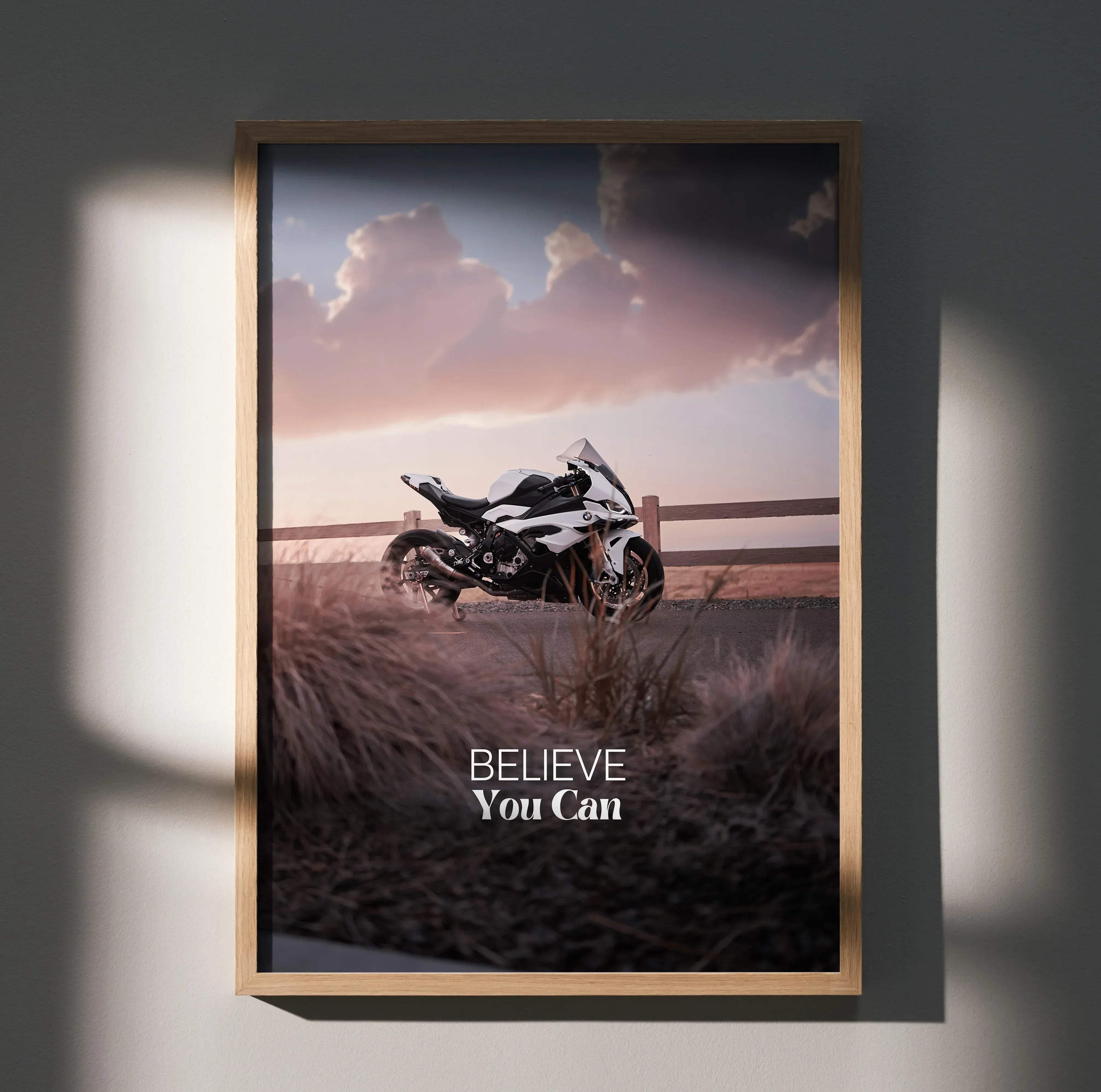 A framed motivational poster featuring a black and white bmw s1000rr sport motorcycle and believe you can text