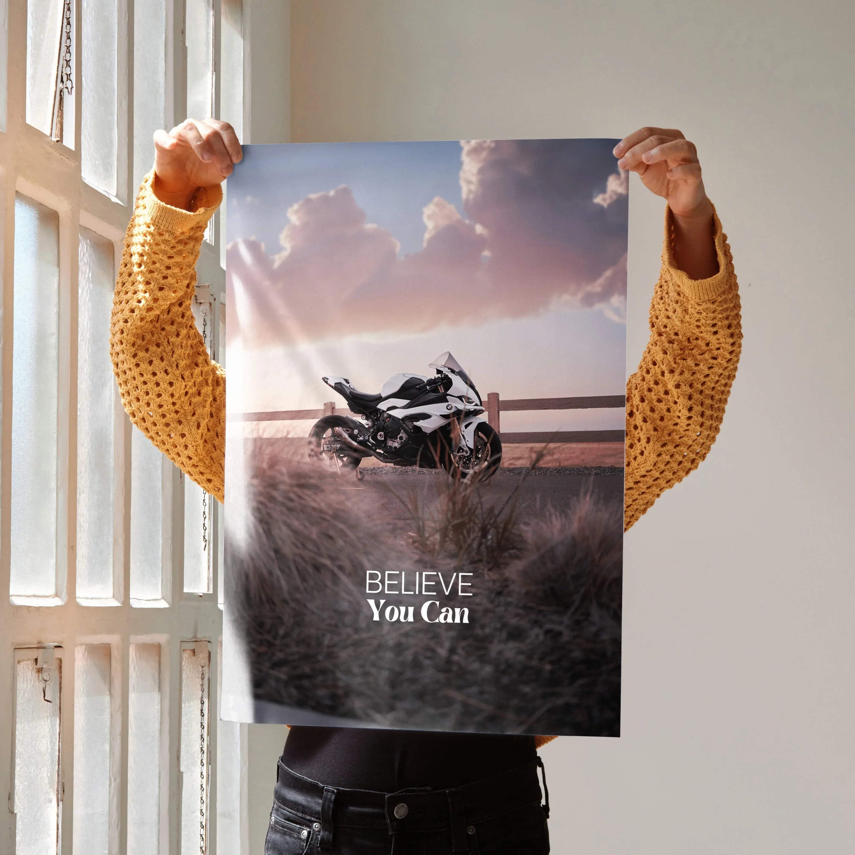 Motivational poster wall art featuring a BMW S1000RR motorcycle with "Believe You Can" text against a sunset sky background.