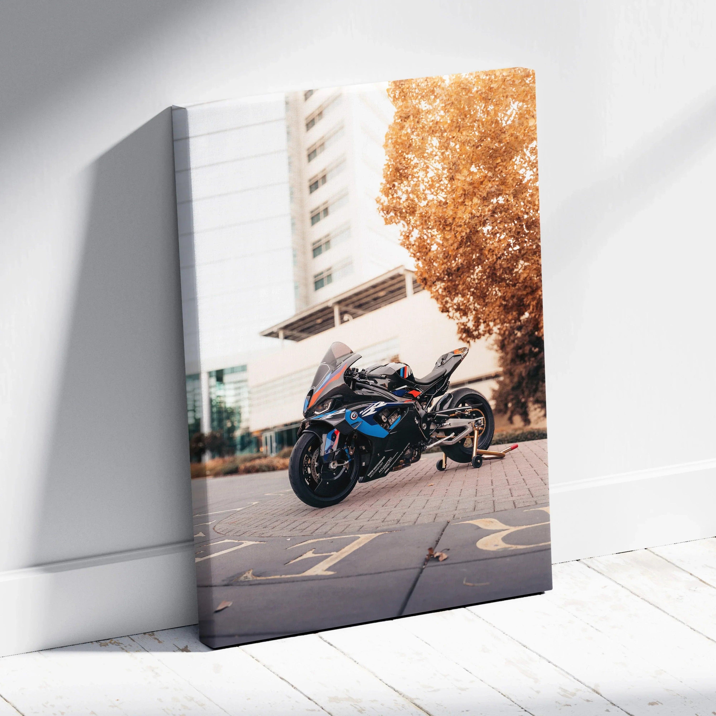 BMW M1000RR motorcycle on canvas wall art with urban background and autumn tree.