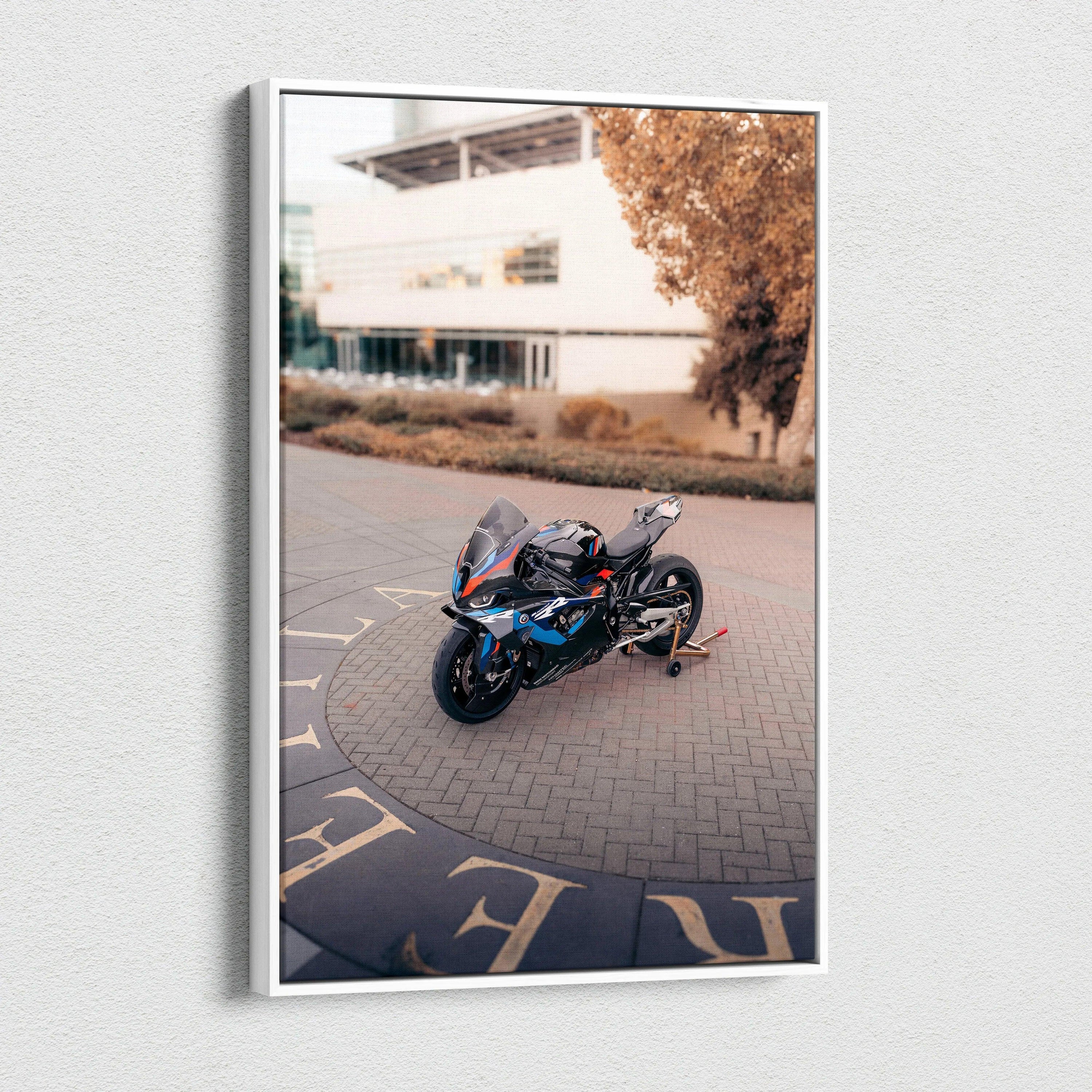Vertical canvas wall art featuring a BMW M1000RR motorcycle parked outdoors with a blurred building background.