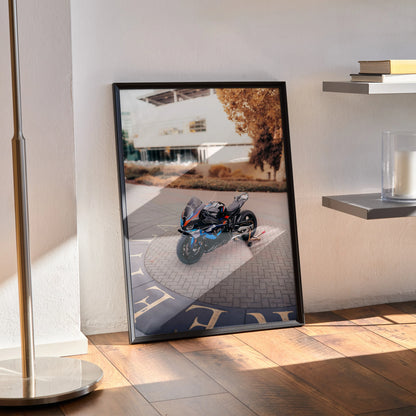 BMW M1000RR motorcycle poster leaning against wall with urban background, premium wall art for bikers.
