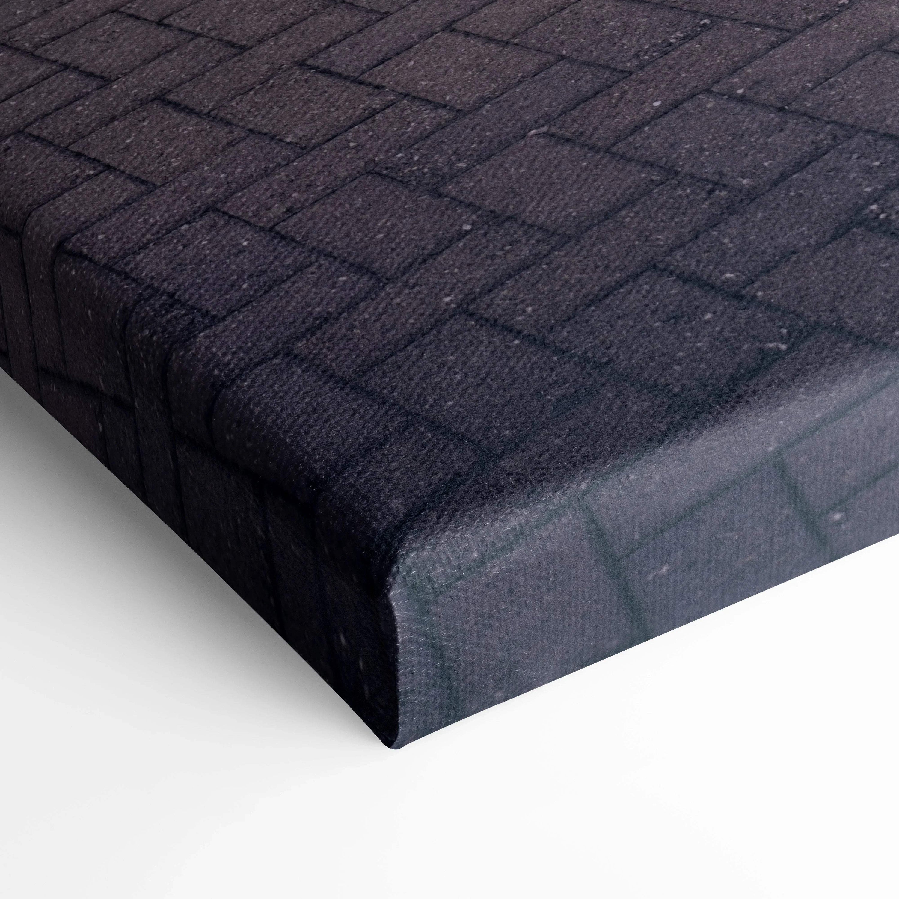 Close-up of textured black brick pattern on vertical canvas wall art with sharp gallery wrap edges.