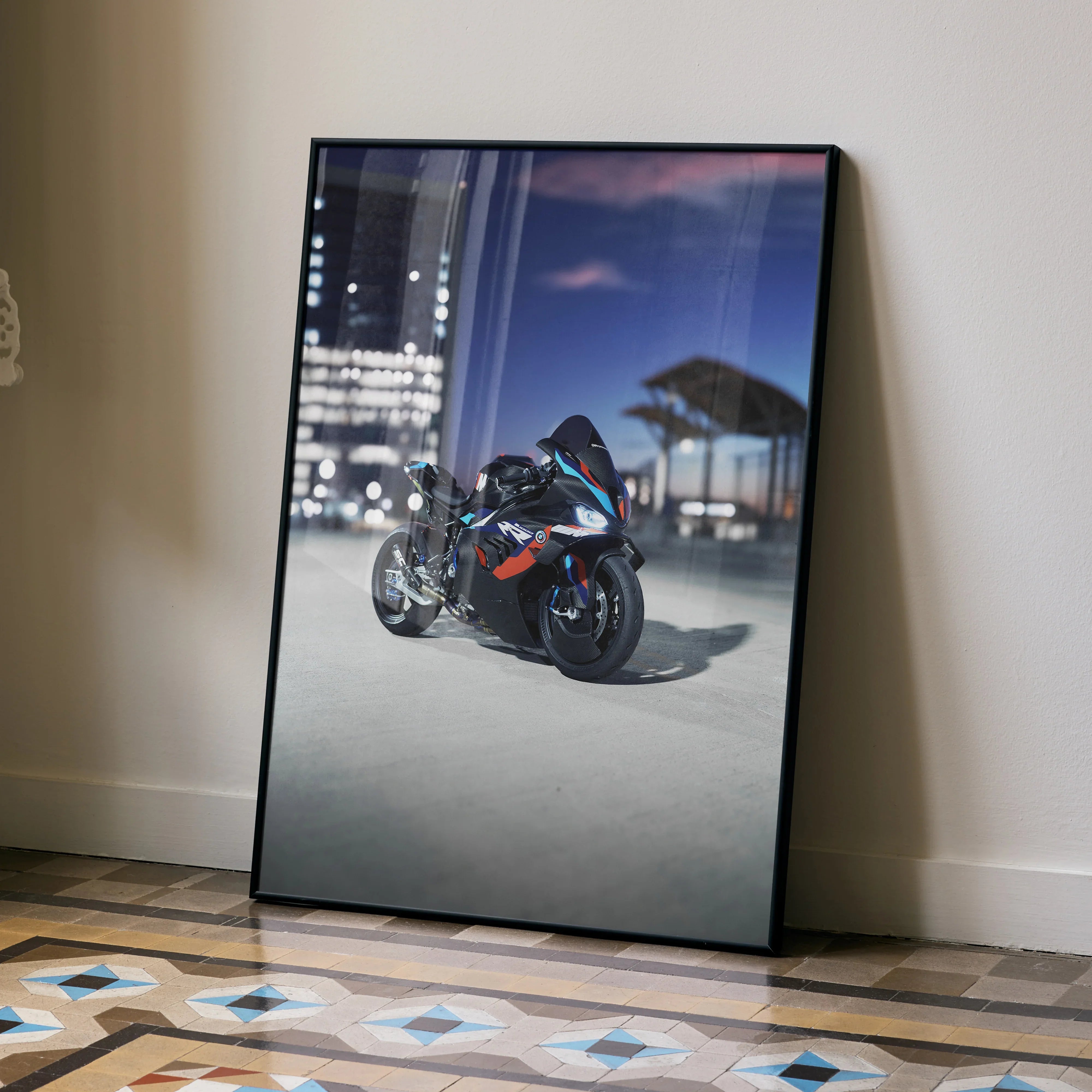 BMW M1000RR motorcycle poster leaning against wall with cityscape background wall art.