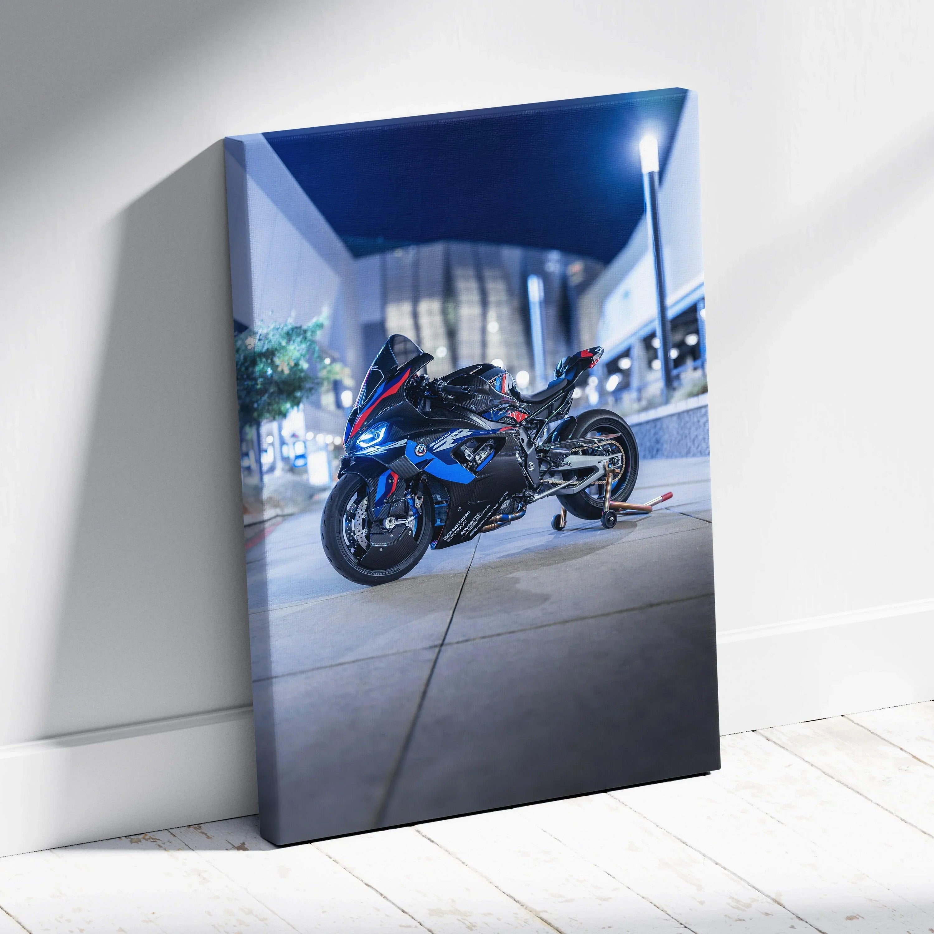 Vertical canvas art featuring a sleek black BMW M1000RR motorcycle parked on an urban sidewalk at night.
