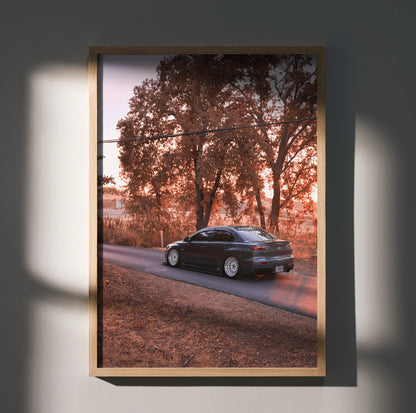 Mitsubishi Evo X poster wall art with black car on road against autumn trees in warm light.