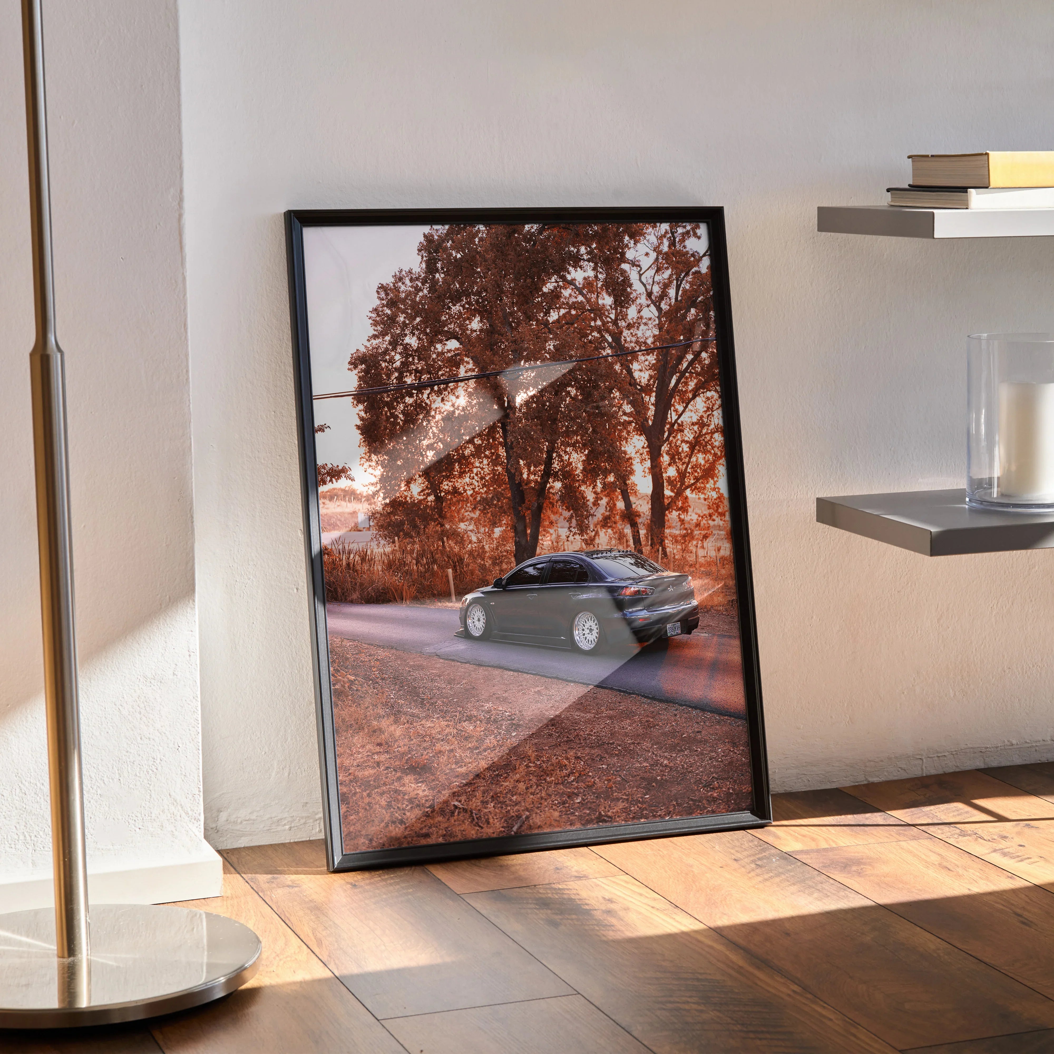 Mitsubishi Evo X poster wall art with sleek black car on autumn road in black frame.