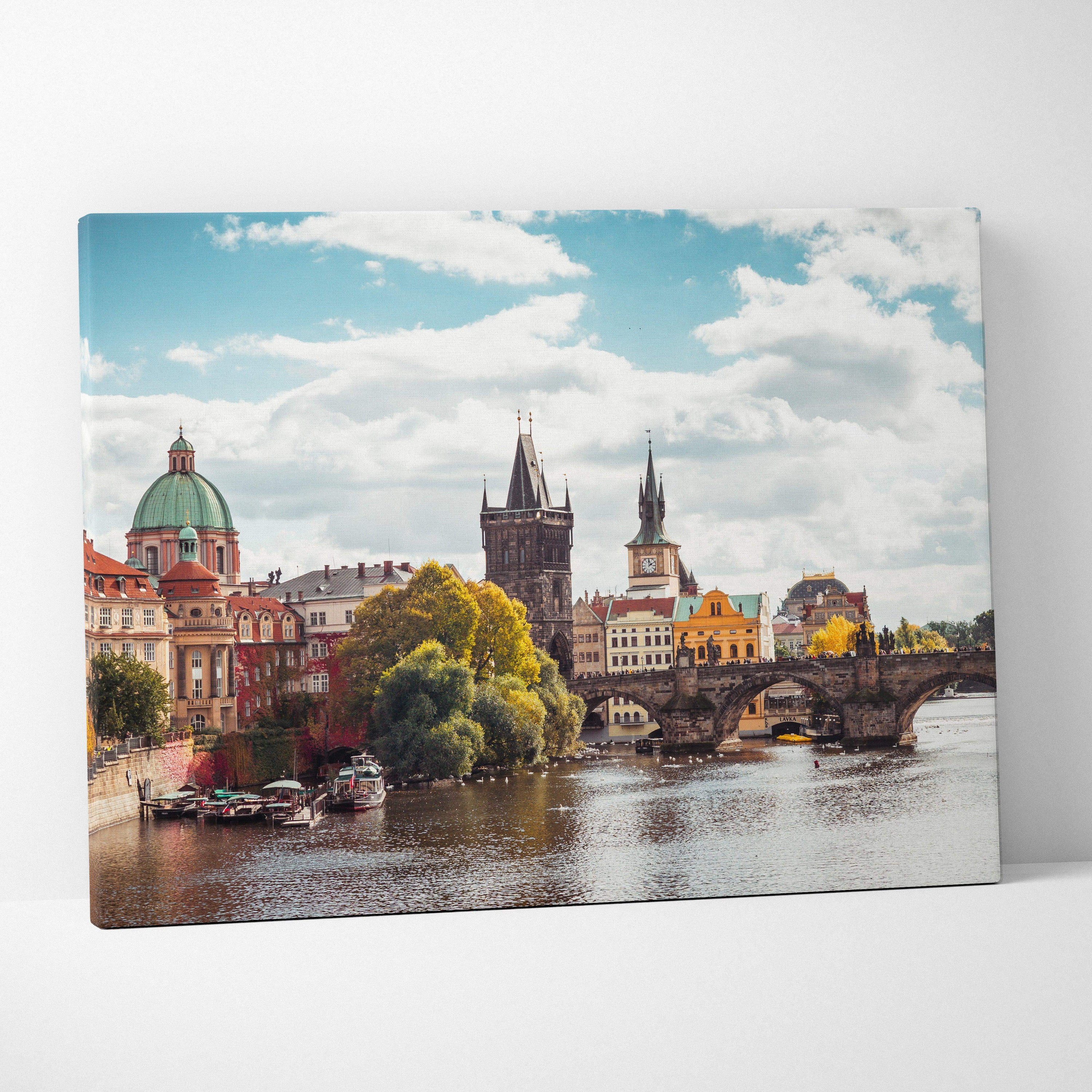 Canvas wall art of historic European buildings and bridge over river under blue sky.