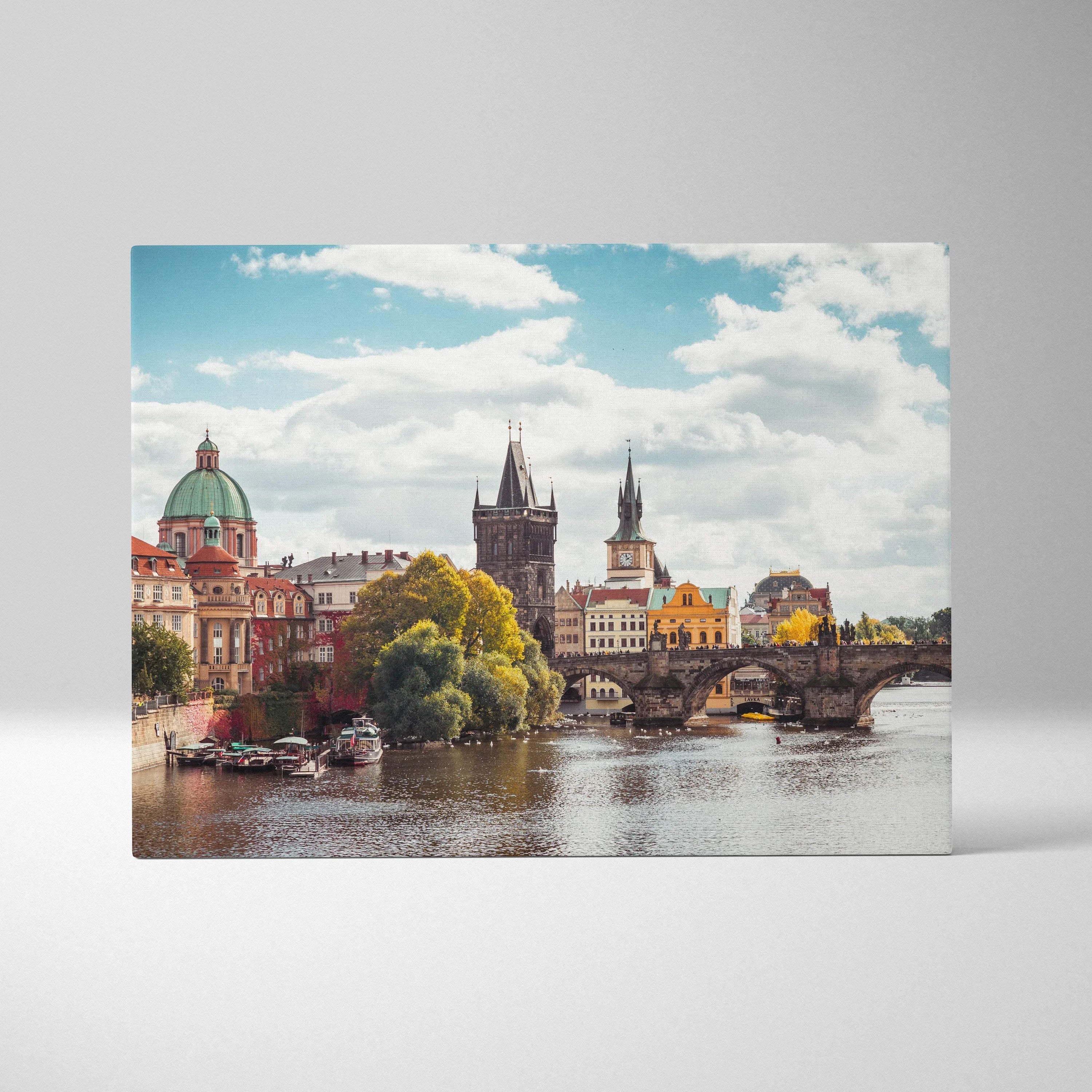 Cityscape canvas wall art featuring historic buildings along a river under a blue sky.