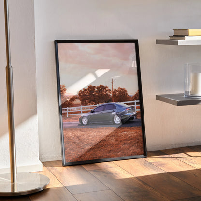 Mitsubishi Evo 10 poster in black frame leaning against wall on wooden floor, car and scenic background wall art.