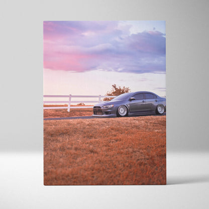 Mitsubishi Evo 10 parked on grass at sunset with purple and pink sky vertical canvas wall art.