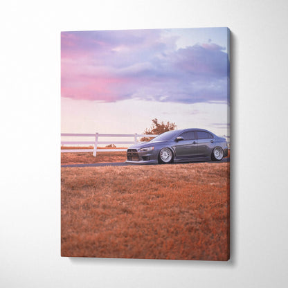 Mitsubishi Evo 10 parked beside white fence at sunset on vertical canvas wall art.
