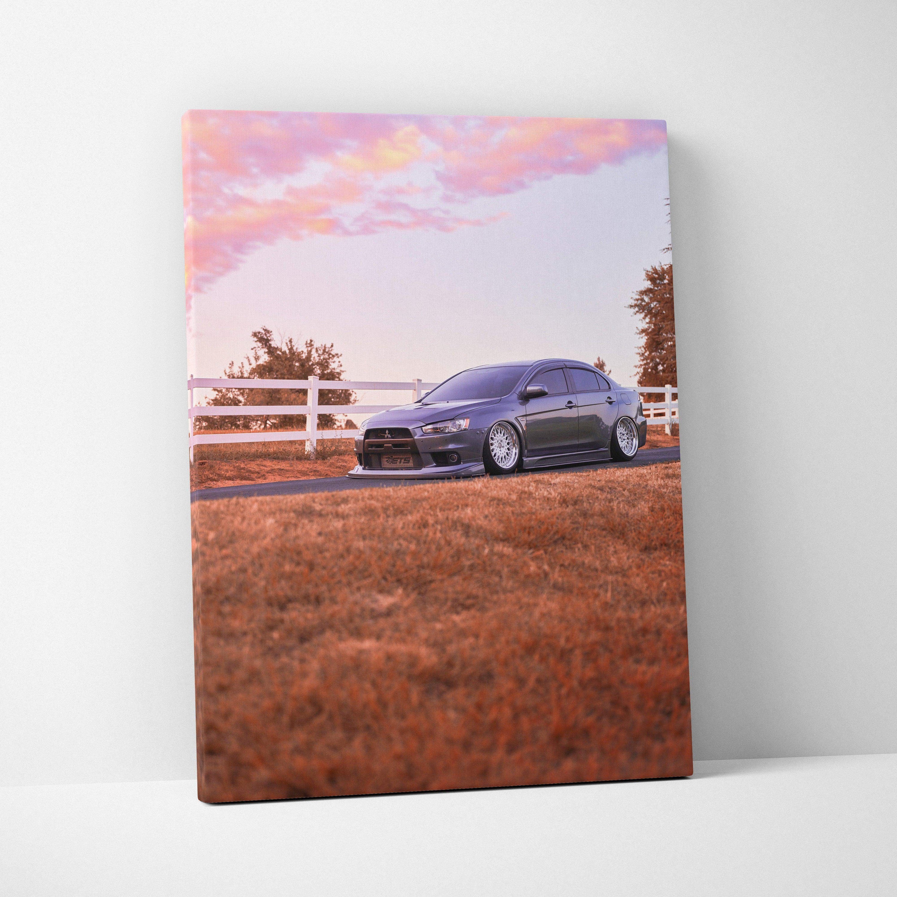 Mitsubishi Evo 10 parked on grass with fence at sunset vivid vertical canvas wall art.