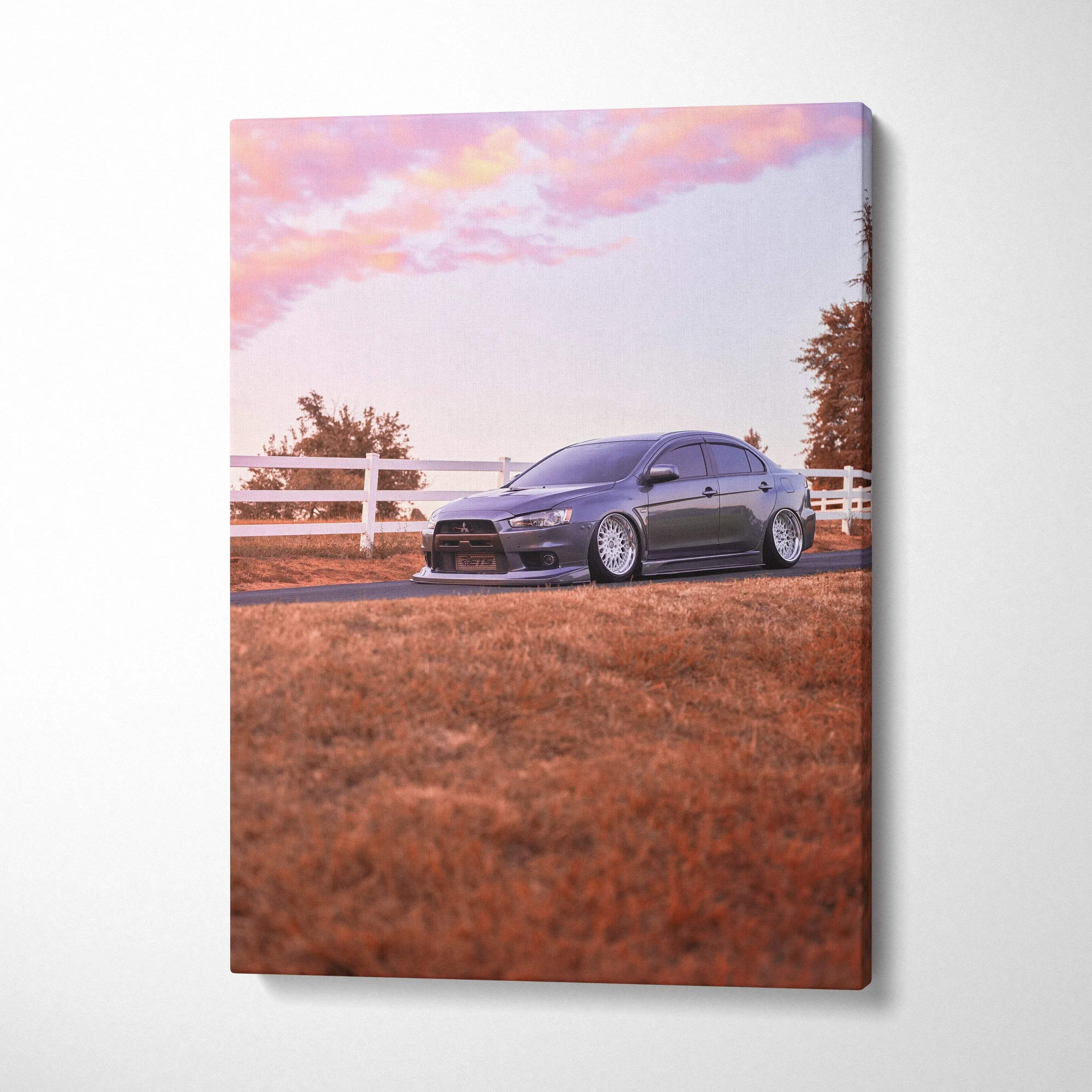 Mitsubishi Evo 10 parked on grass near white fence at sunset canvas wall art.